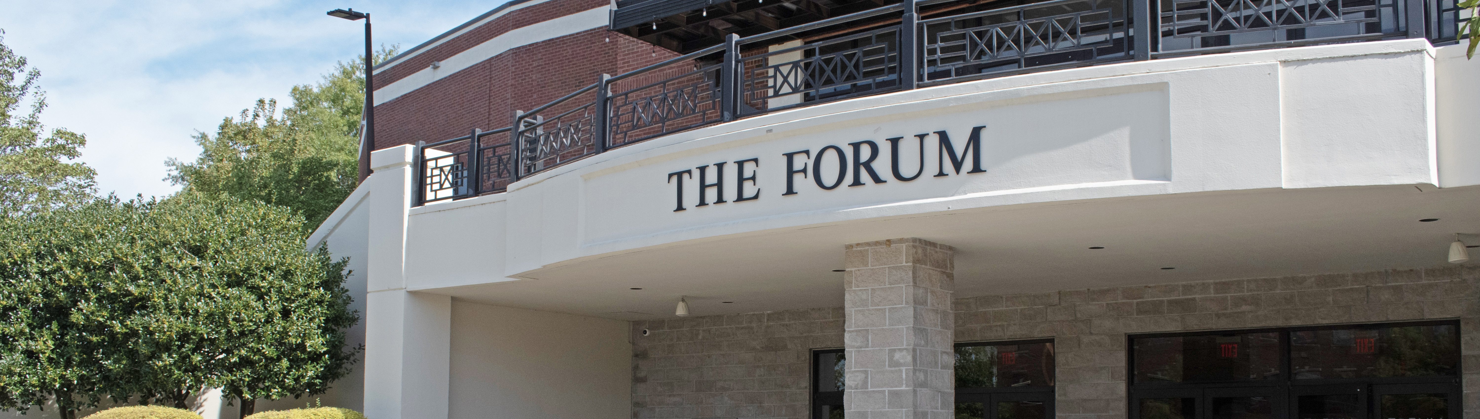 A building with a few bushes around it, with "The Forum" on the outside.